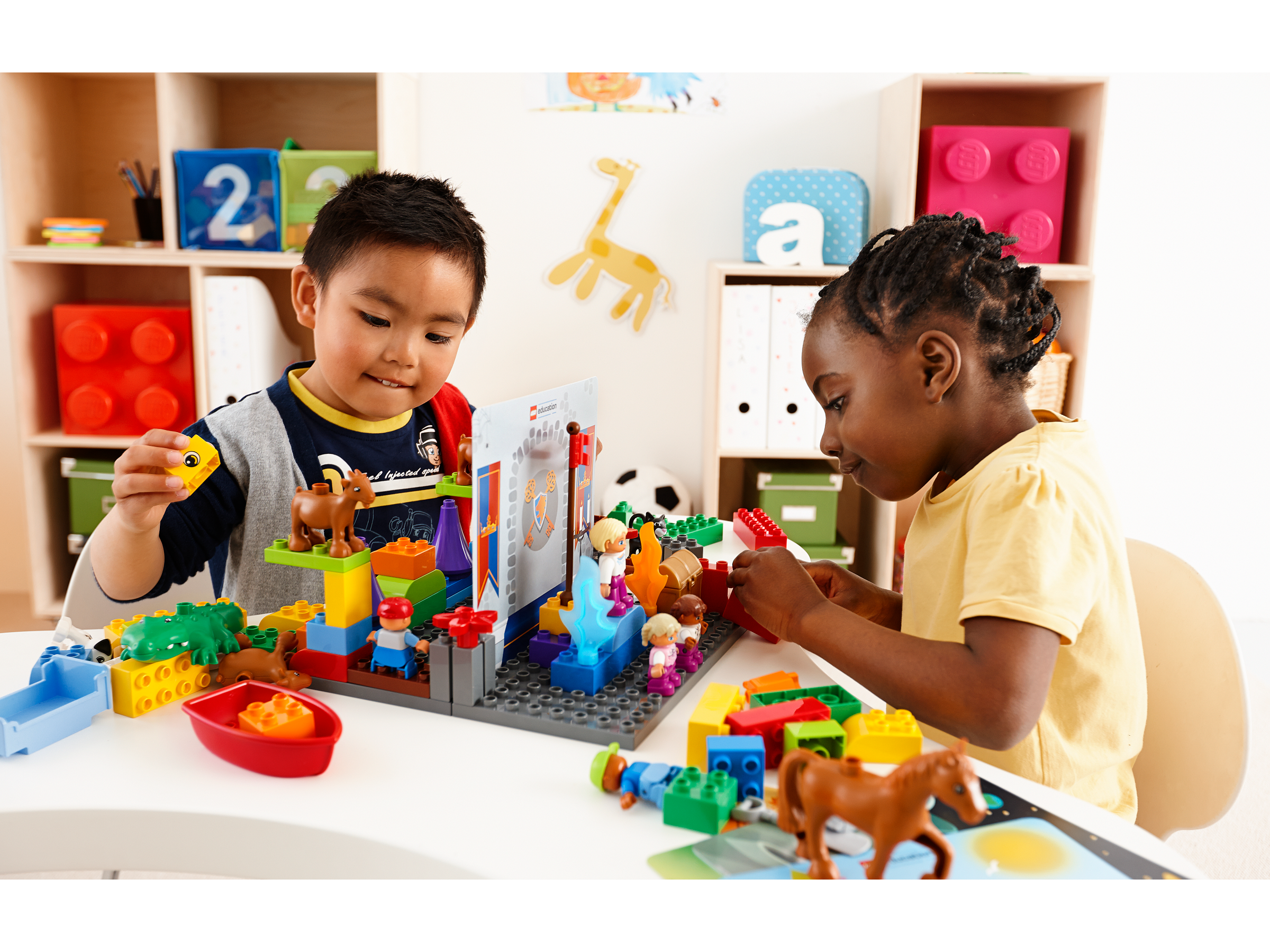 Two preschool children playing with StoryTales by LEGO® Education, developing their storytelling skills.